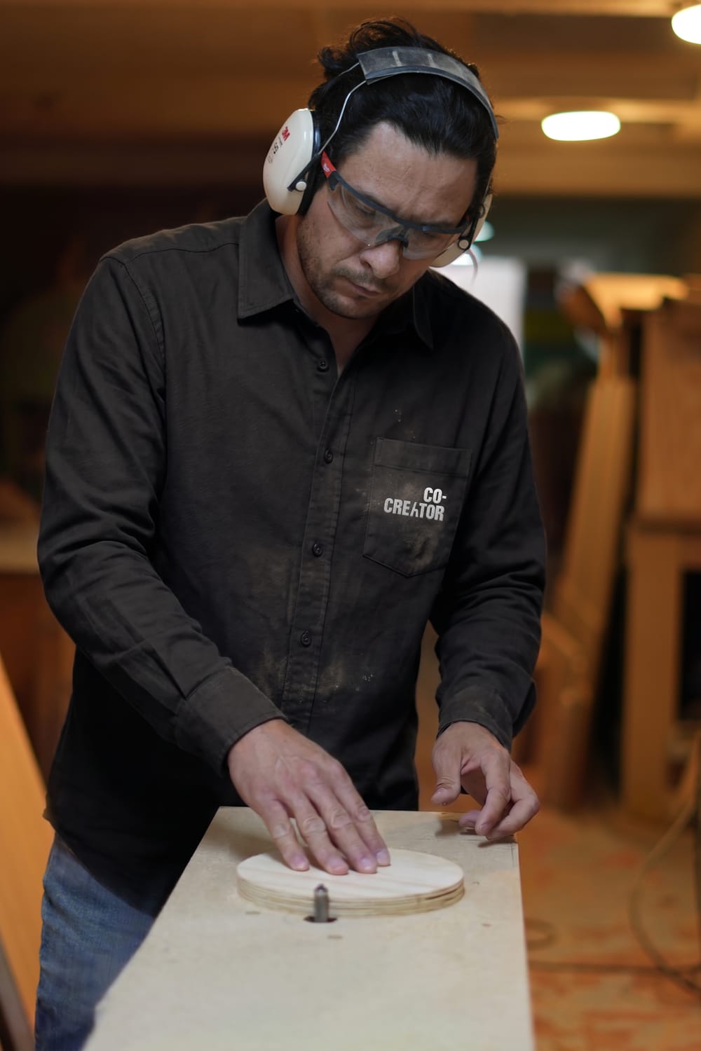 Iván Ramírez, maestro carpintero de Co-Creator, trabajando una pieza de madera en el taller