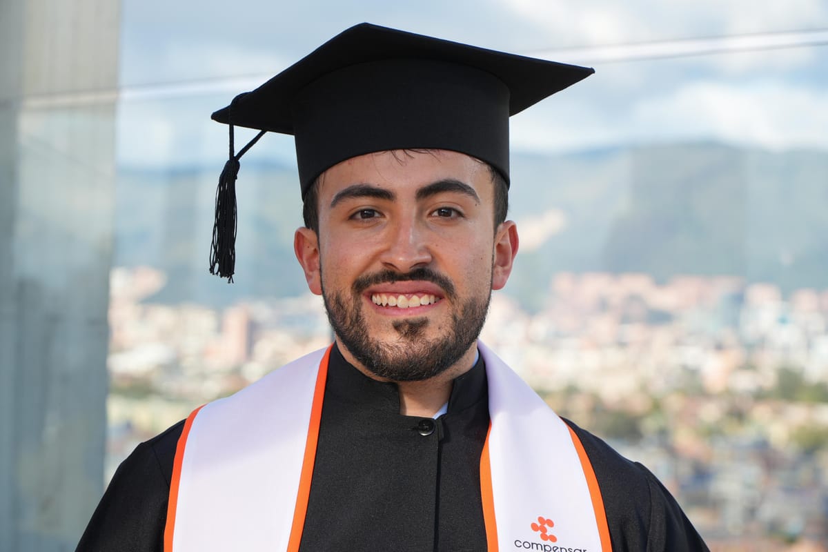 Retrato de Gabo sonriendo con birrete y banda de graduación, con la ciudad de Bogotá desenfocada al fondo